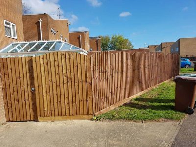 6 foot tall feathered edge fence with a curved over top and a gate