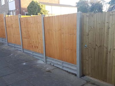 brown wood feathered edge fence with concrete gravel boards